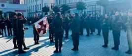 Zdjęcie przedstawia moment ślubowania. Widać umundurowanych żołnierzy 71 Batalionu Lekkiej Piechoty 7 Pomorskiej Brygady Obrony Terytorialnej, w tle budynki rynku miejskiego.