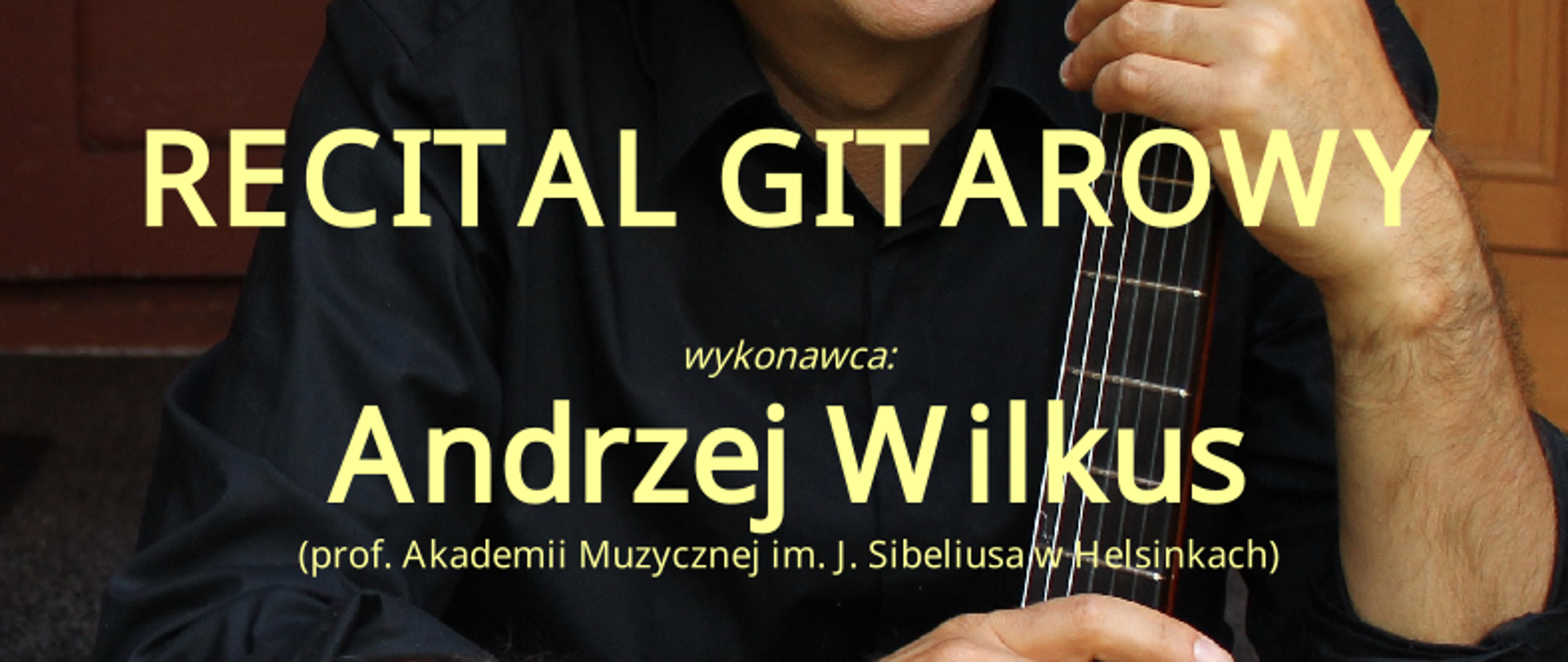prof. Andrzej Wilkus w słomkowym kapeluszu i okularach trzymający gitarę