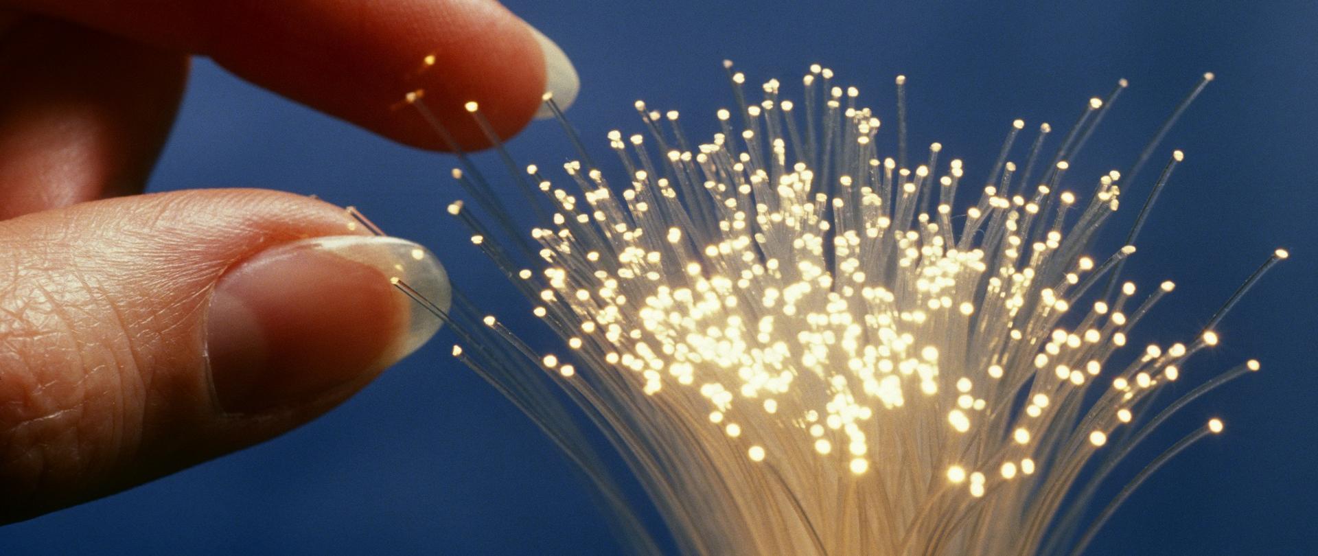 Palec dotykający wiązki światłowodów.