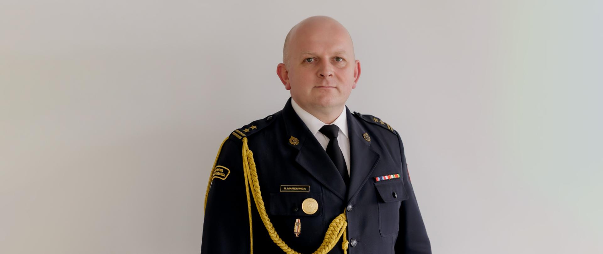 Zdjęcie portretowe mł. bryg. Romana Marekwicy w mundurze na jasnym tle