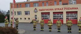 Zdjęcie przedstawia strażaków podczas wciągania flagi państwowej na maszt