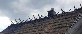 Widoczne miejsce zdarzenia dach kryty strzechą, fragment dachu zniszczony w wyniku pożaru.