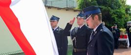 Strażacy OSP Charzykowy wieszają flagę.