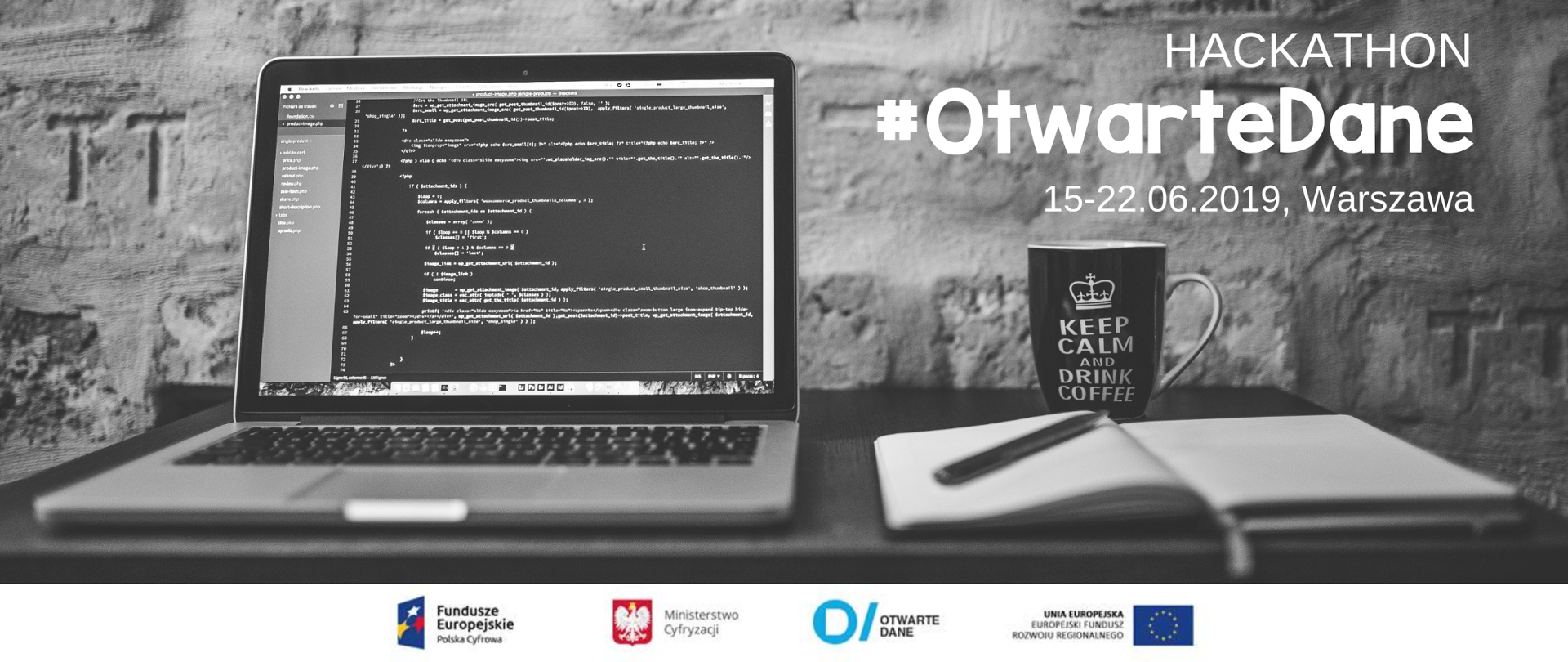 Grafika. Na stole leżą otwarty laptop, kubek i notes z długopisem.