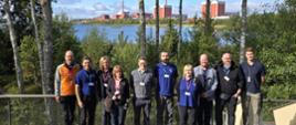 Uczestnicy spotkania polsko-fińskiego pozują do zdjęcia na tle elektrowni jądrowej