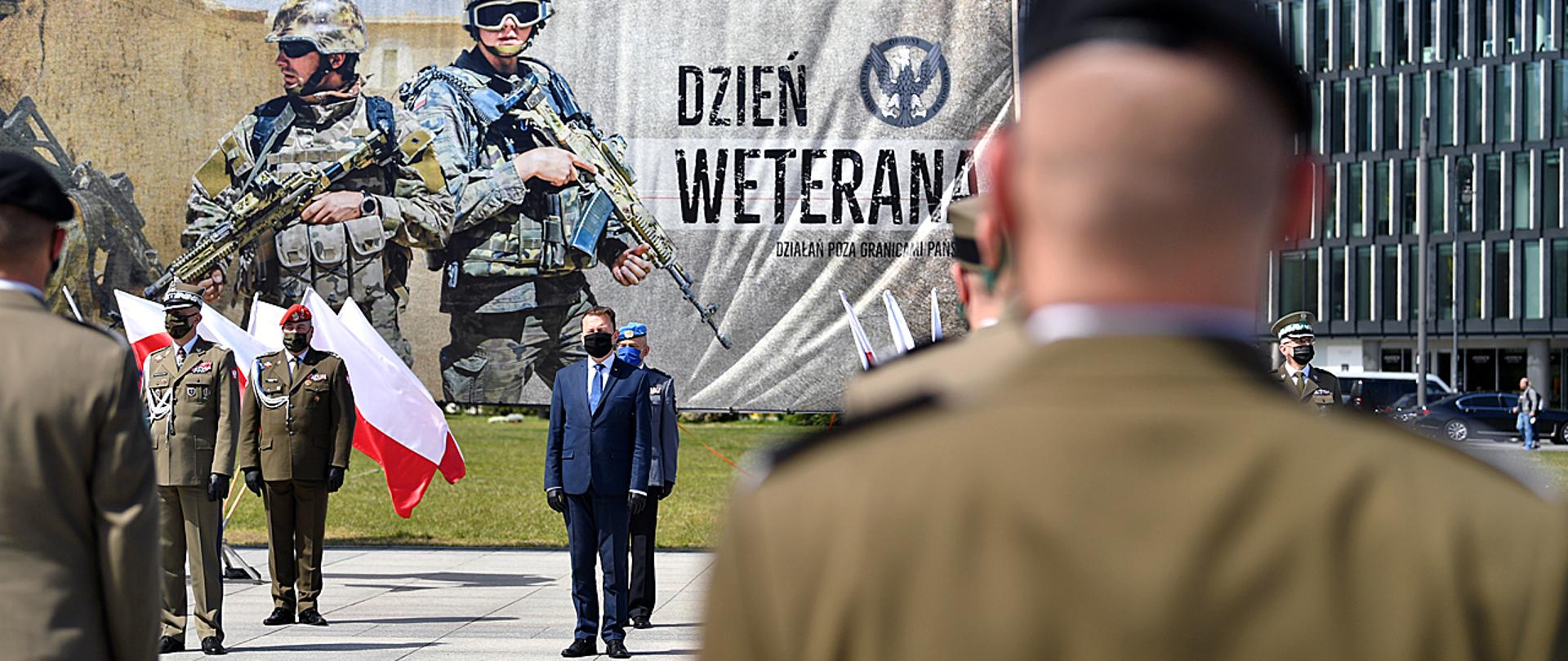 Obchody Dnia Weterana w Warszawie. Minister Mariusz Błaszczak stoi z weteranami.