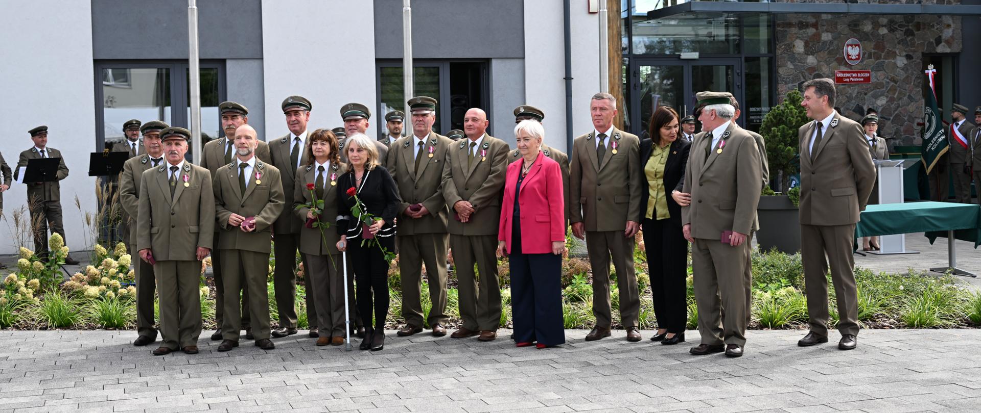 Pamiątkowa fotografia wojewody łódzkiego Doroty Ryl z wyróżnionymi pracownikami łódzkiej Dyrekcji Lasów Państwowych 