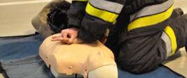 Strażak ćwiczy uciśnięcia klatki piersiowej podczas egzaminu na strażaka ratownika OSP