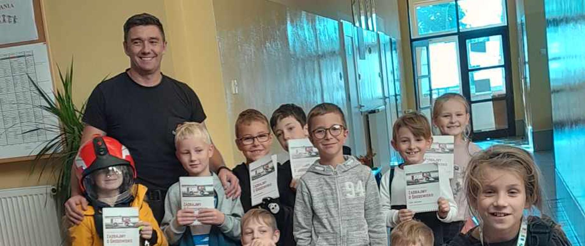 Grupowe zdjęcie dzieci ze strażakiem