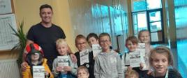 Grupowe zdjęcie dzieci ze strażakiem