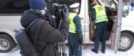 Kontrola autokaru w miejscu wyjazdu harcerzy z Radomia. Inspektorzy pobierają wymagane dokumenty od kierowcy.