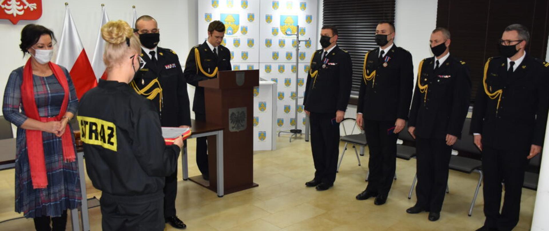 Na zdjęciu Pani Senator RP, Warmińsko-Mazurski Komendant Powiatowy, funkcjonariusze PSP oraz druhna OSP Chełchy w trakcie wręczania awansów i odznaczeń.