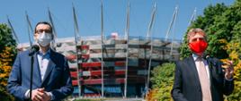 Premier Mateusz Morawiecki i Zbigniew Boniek stoją na tle Stadionu Narodowego.