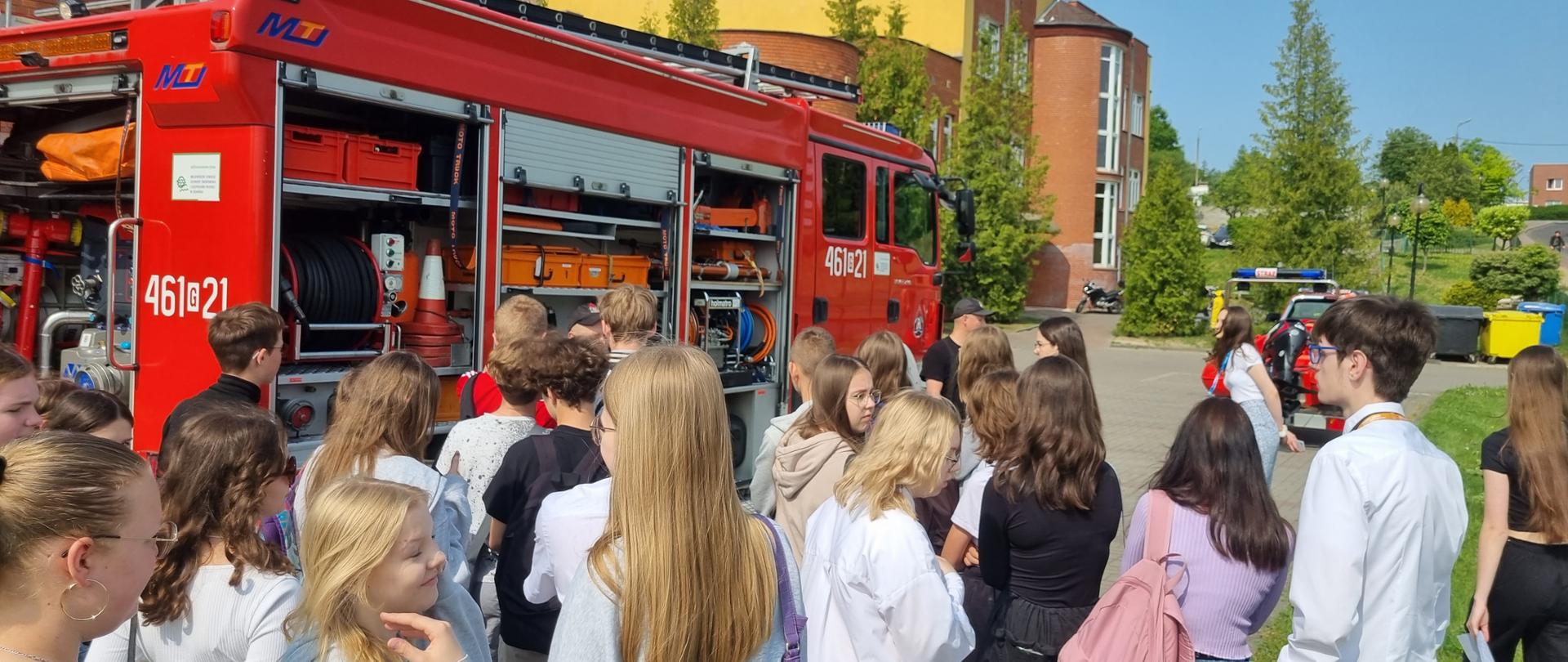 Uczniowie ZSO nr 2 w Kwidzynie oglądają sprzęt ratowniczo-gaśniczy, znajdujący się na samochodzie pożarniczym.