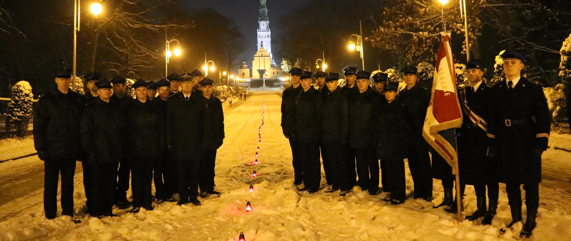 Po lewej Komendant Centralnej Szkoły PSP w towarzystwie kadetów CS PSP, po prawej poczet sztandarowy CS PSP w towarzystwie kadetów CS PSP. W głębi wieża klasztoru jasnogórskiego