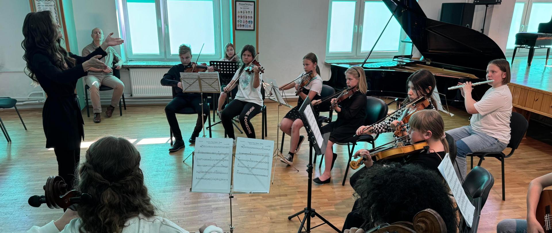 Zdjęcie przedstawiające wykonawców podczas koncertów w auli szkoły w dniach 13-14.05.2024 r. w ramach dni otwartych szkoły.