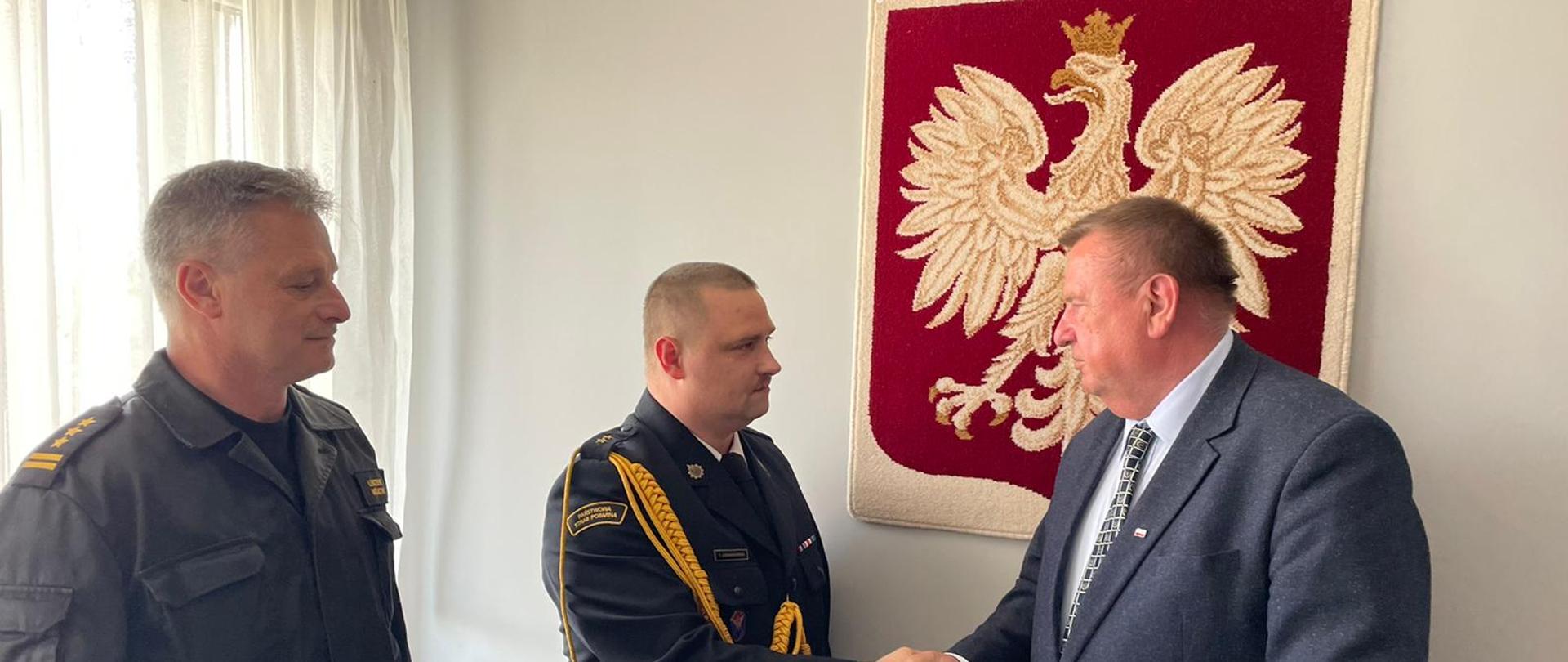 Poseł na Sejm RP Krzysztof Czarnecki wręczający życzenia Komendantowi powiatowemu