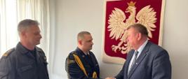 Poseł na Sejm RP Krzysztof Czarnecki wręczający życzenia Komendantowi powiatowemu