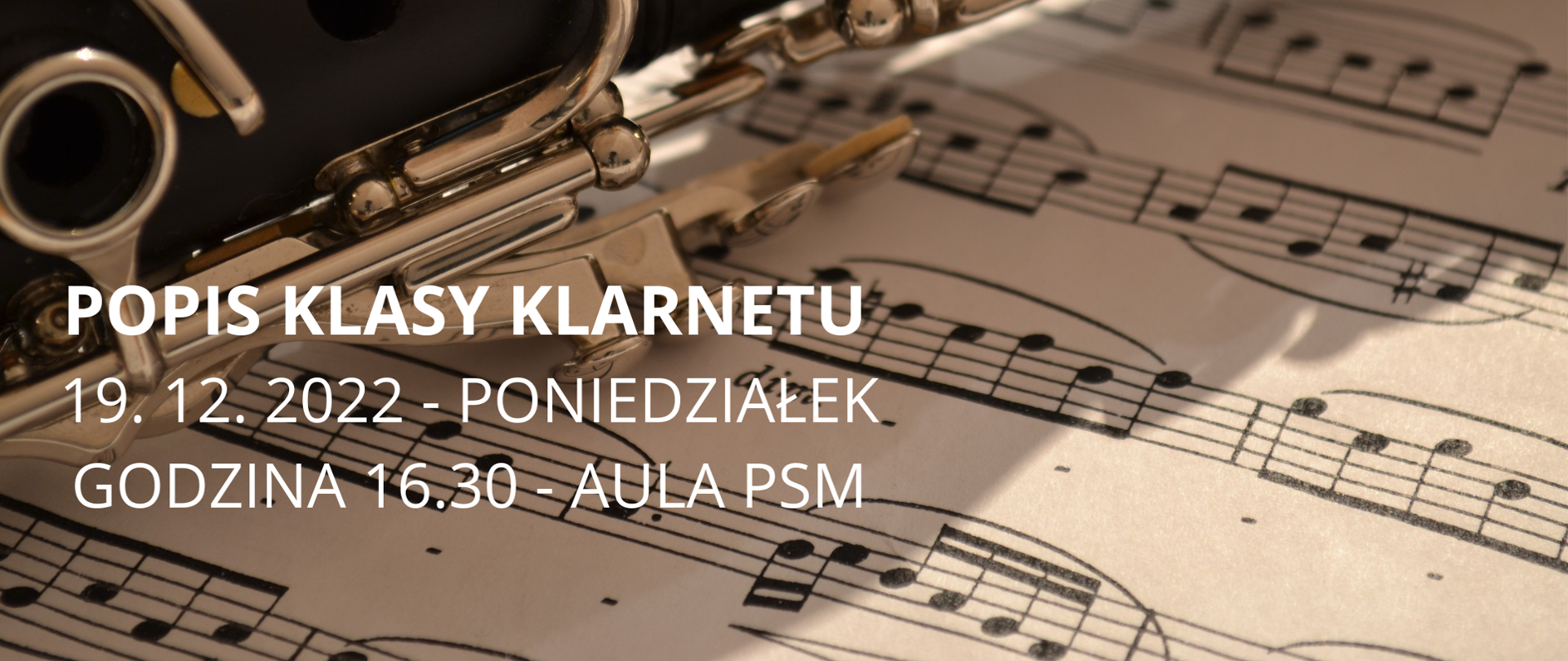 Na plakacie widać środkową część klarnetu w kolorze czarnym, w tle kartka z nutami, lekko z lewej biały napis Popis klasy klarnetu 19. 12. 2022 - poniedziałek godzina 16.30 - aula PSM