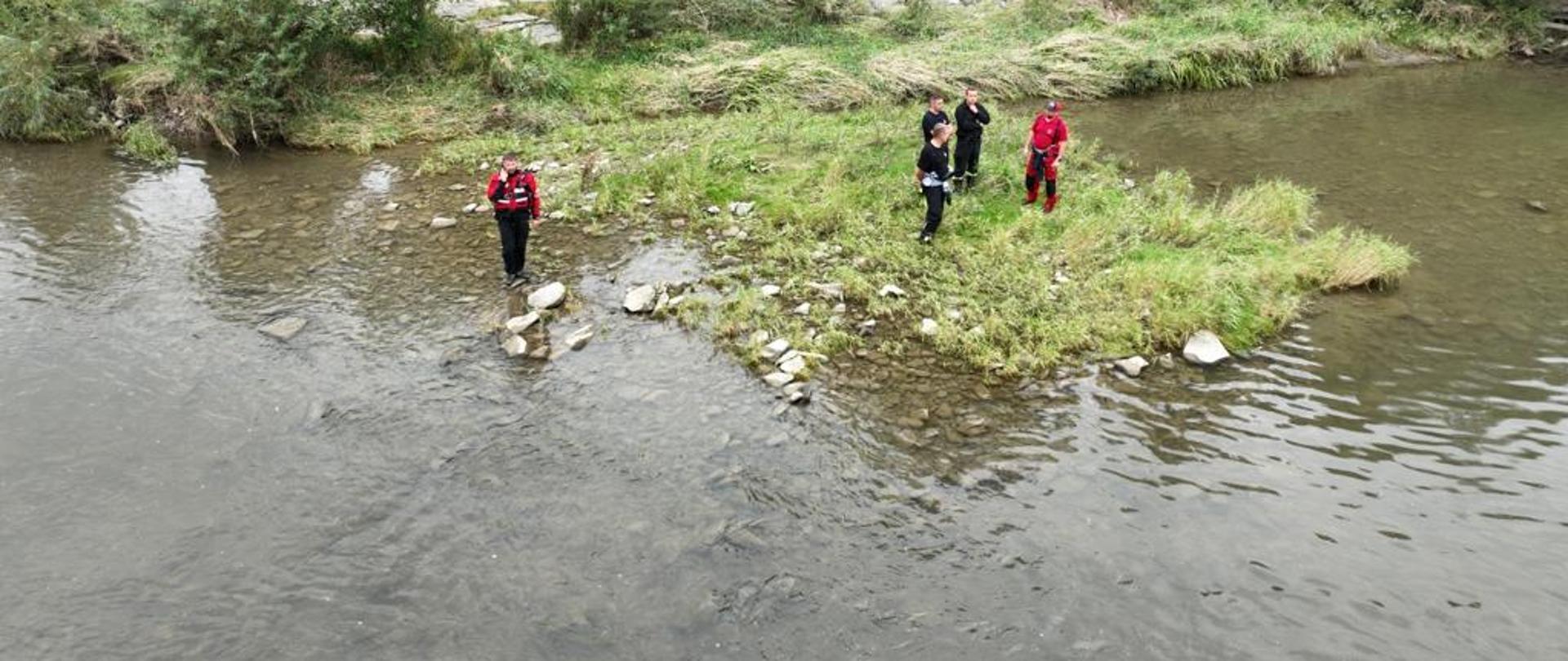Ratownicy nad brzegiem rzeki Poprad