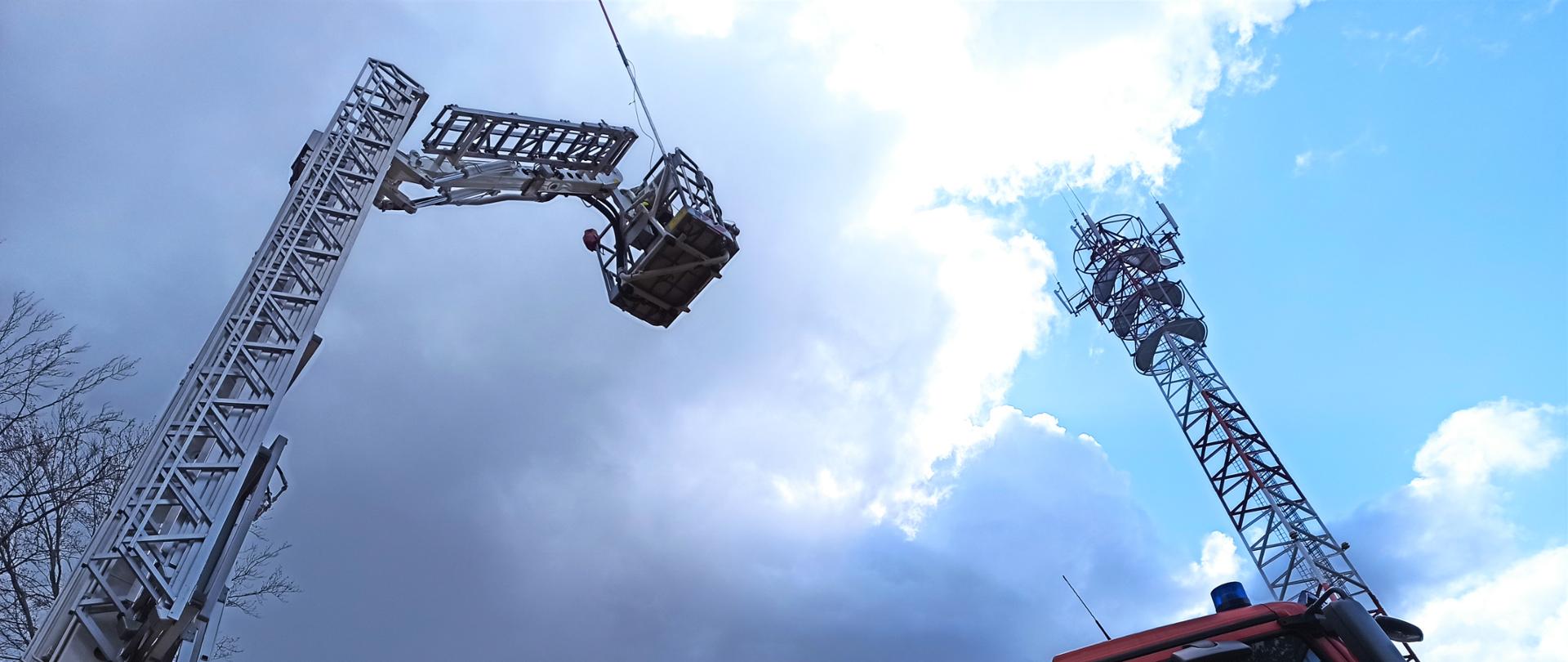 Na zdjęciu ramię podnośnika SHD 25 z tymczasową anteną radiową w tle widać maszt antenowy