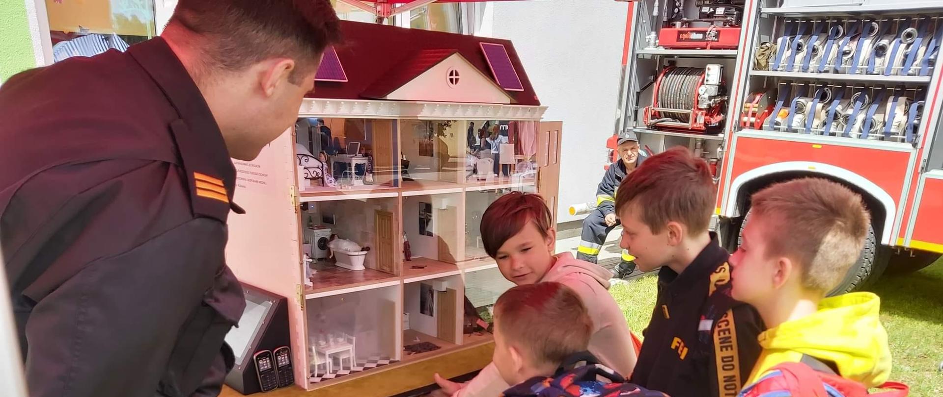 Zdjęcie przedstawia pokaz symulatora zagrożeń pożarowych domu jednorodzinnego