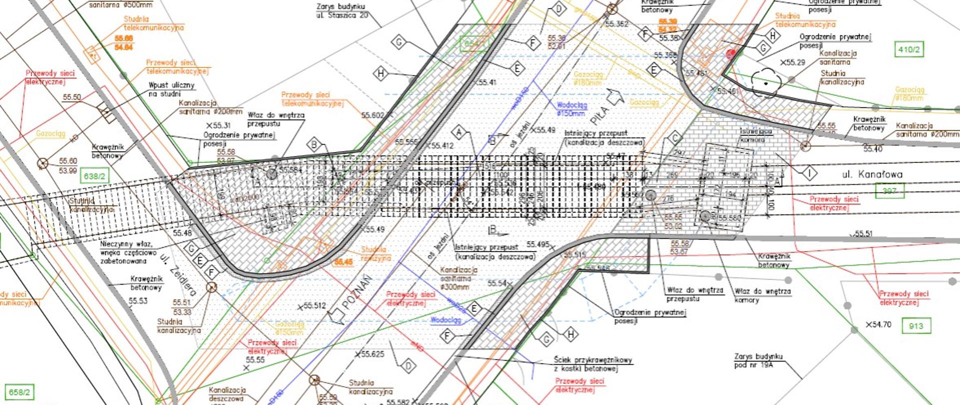 Techniczny plan sytuacyjny przedstawiający rozbudowany układ drogowy z licznymi warstwami oznaczeń projektowych. W centralnej części widoczny jest główny odcinek jezdni z pasami ruchu, chodnikami oraz elementami infrastruktury podziemnej oznaczonymi kolorowymi liniami i symbolami. Po bokach znajdują się rozwidlenia i łuki dróg, a całość zawiera podpisy dotyczące sieci energetycznych, wodociągowych, telekomunikacyjnych i gazowych. W prawym dolnym rogu umieszczono różę wiatrów wskazującą kierunki geograficzne.