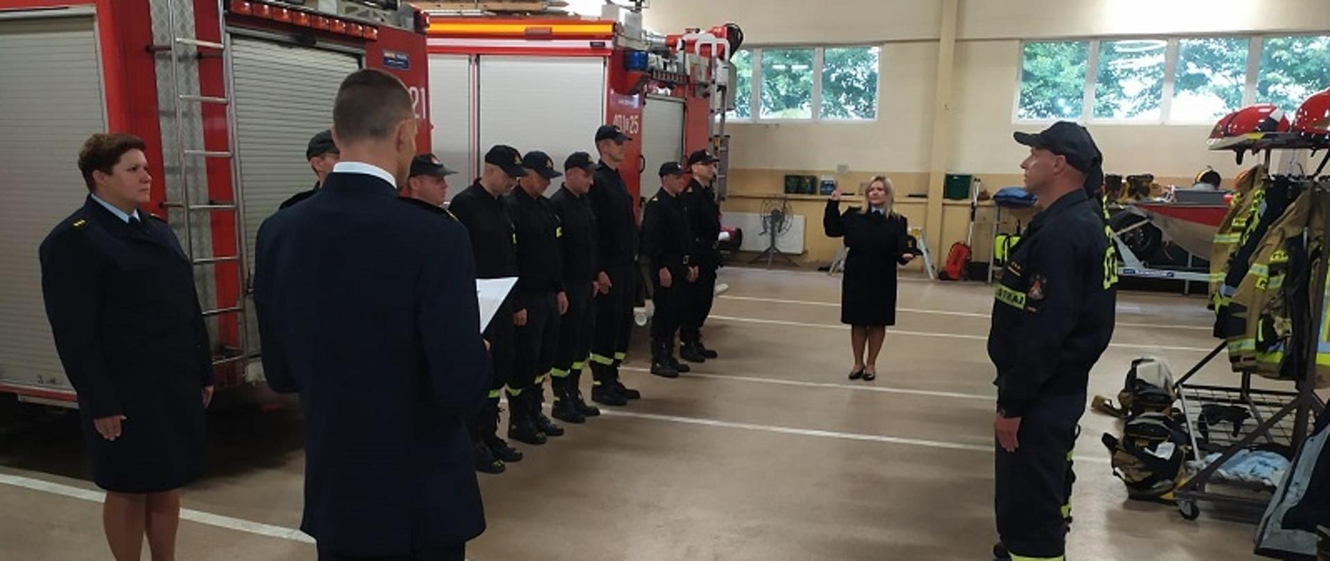 Zbiórka strażaków w garażu jednostki w umundurowaniu koszarowym podczas którego nastąpiło złożenie ślubowania.