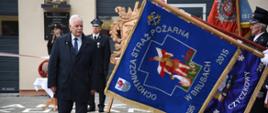Wicewojewoda pomorski przechodzi przed sztandarami ochotniczych straży pożarnych. 