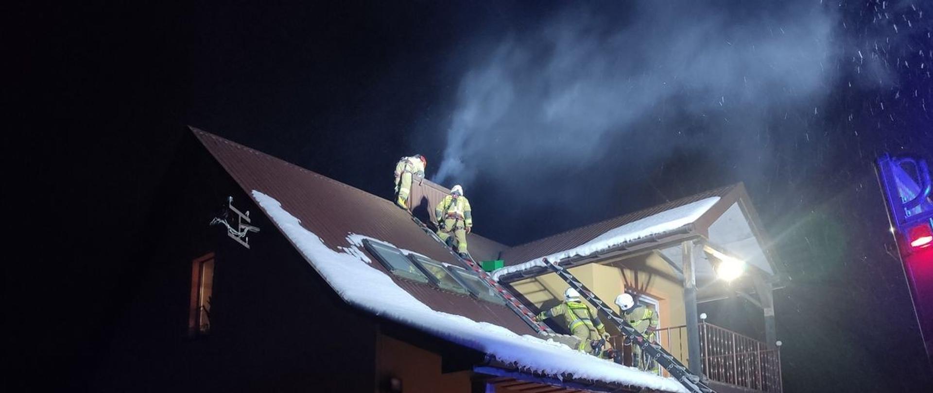 Strażacy prowadzą działania na dachu przy kominie