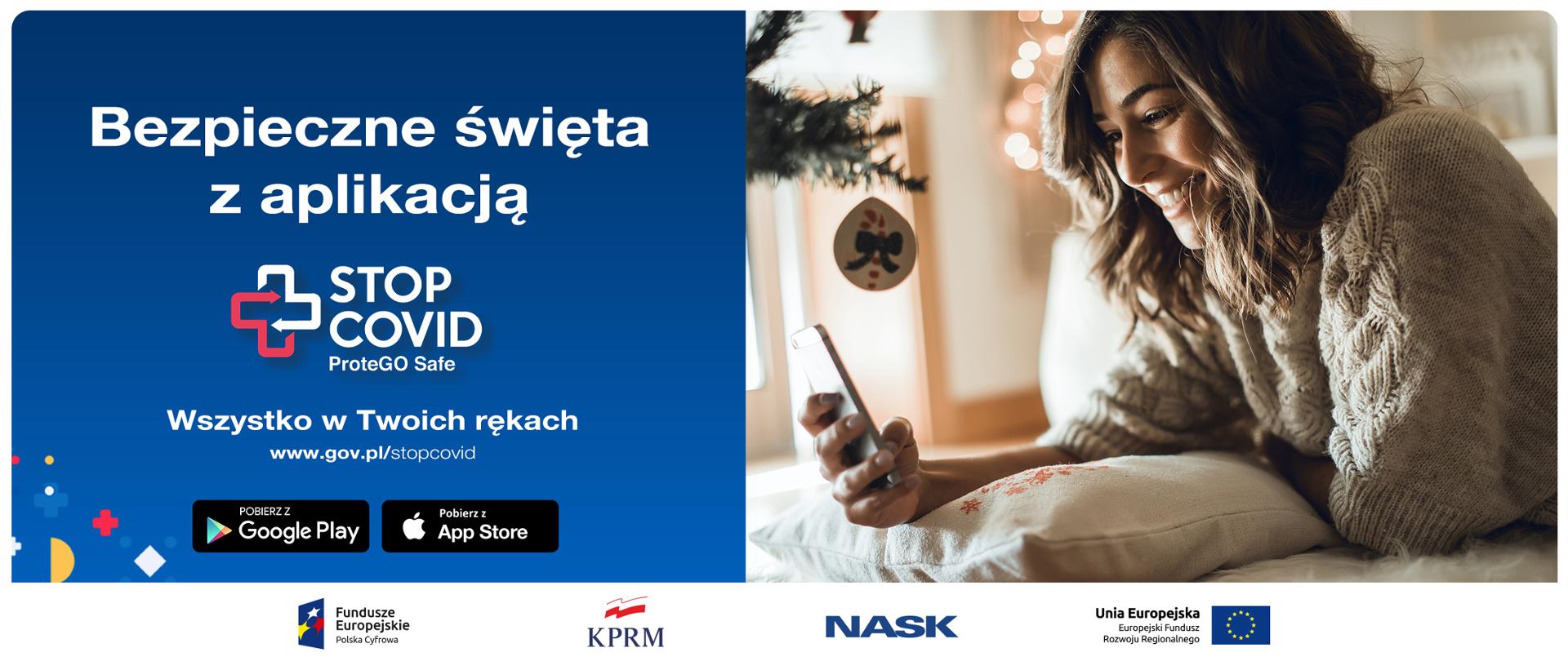 Ekran podzielony na pół. Z prawem strony kobieta obok bożonarodzeniowej choinki - opiera się o poduszkę, patrzy na trzymany w dłoni telefon. Z lewej strony, na granatowym tle tekst: Bezpieczne święta z aplikacją STOP COVID ProteGo Safe. Wszystko w Twoich rękach. www.gov.pl/stopcovid