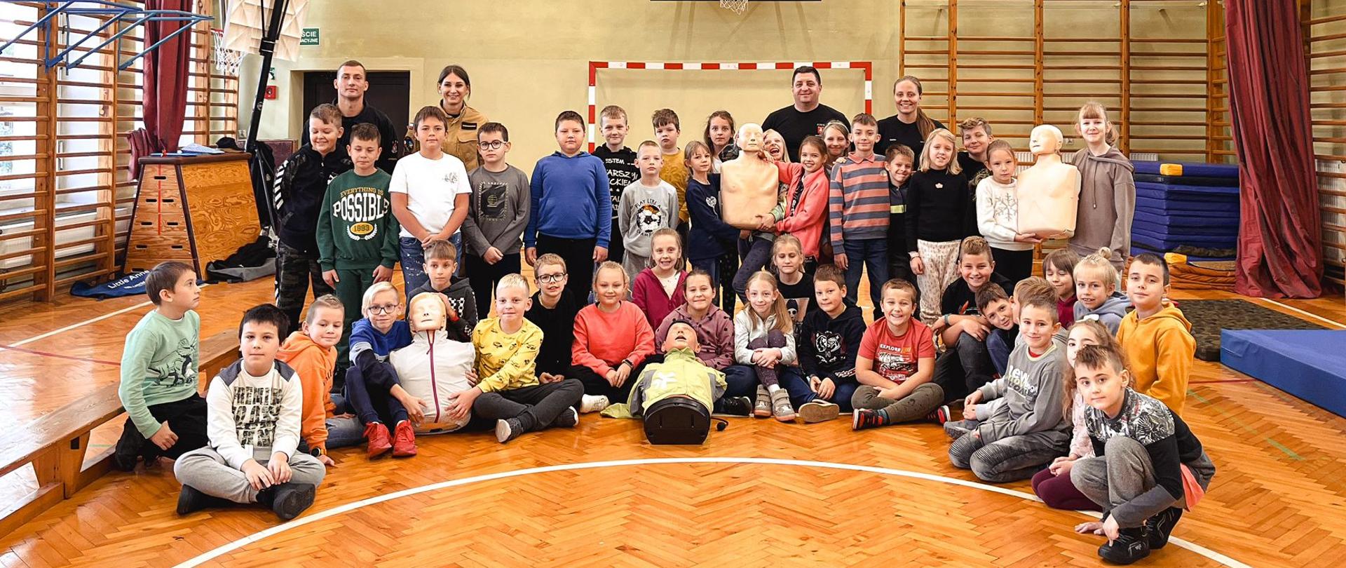 Uczestnicy projektu przywracania czynności serca. Zdjęcie wykonane w sali gimnastycznej szkoły.