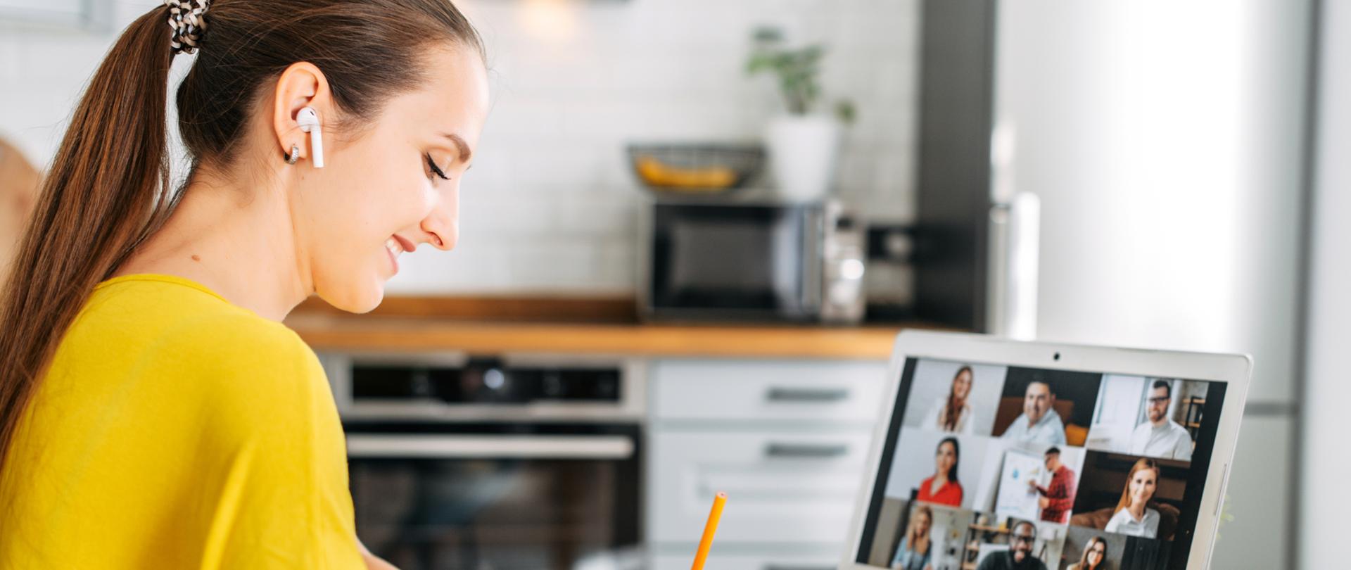 Osoba siedząca przy laptopie, widoczne ręce na klawiaturze. Na ekranie komputera napis webinar