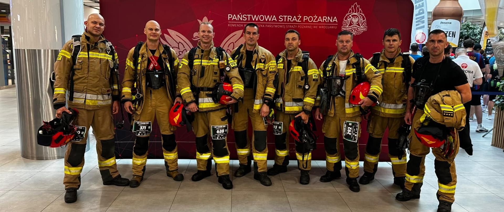 Strażacy stoją na wspólnym zdjęciu przed zawodami. 