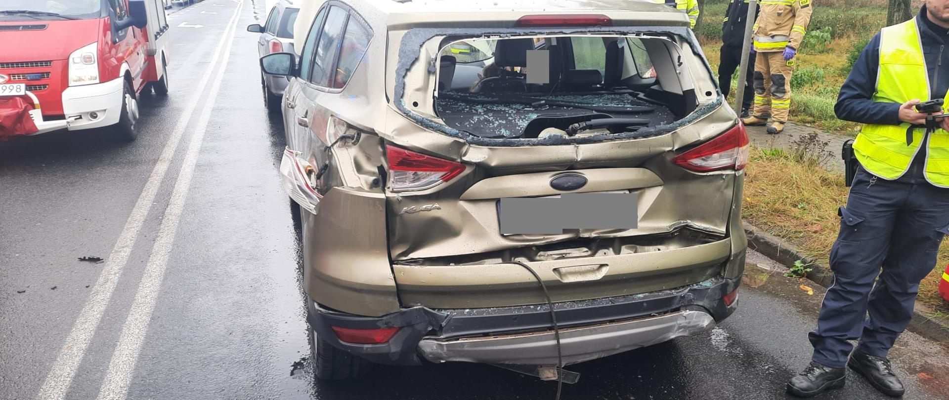 Uszkodzony tył złotego samochodu osobowego typu van