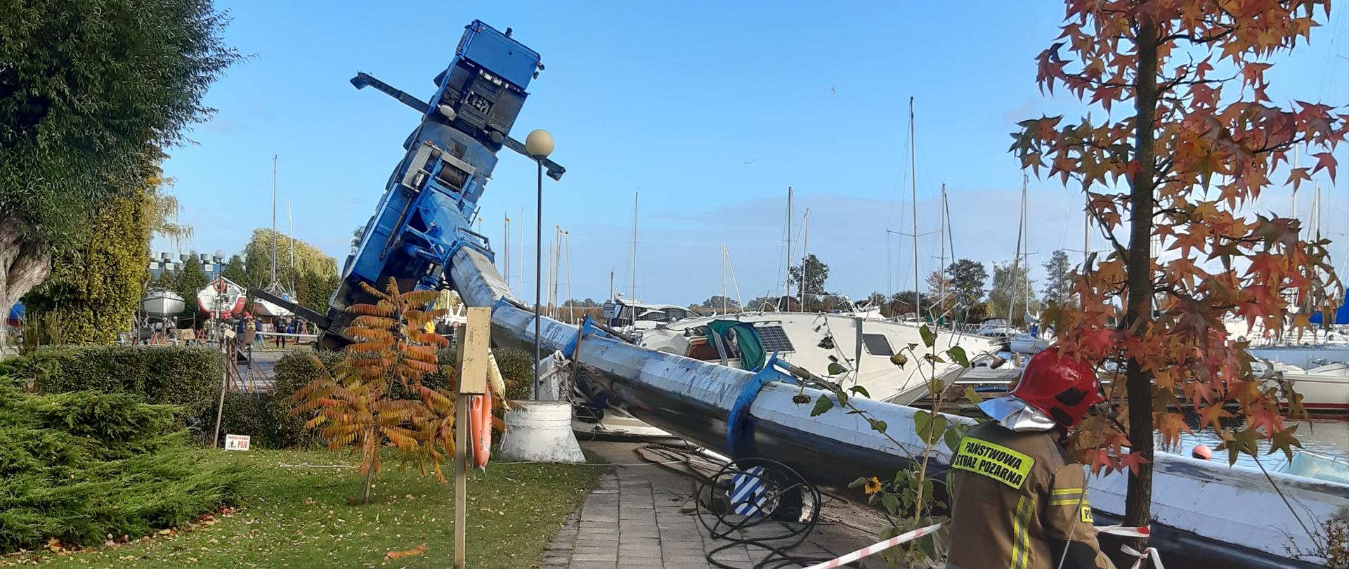 Przewrócony dźwig na przystani jachtowej
