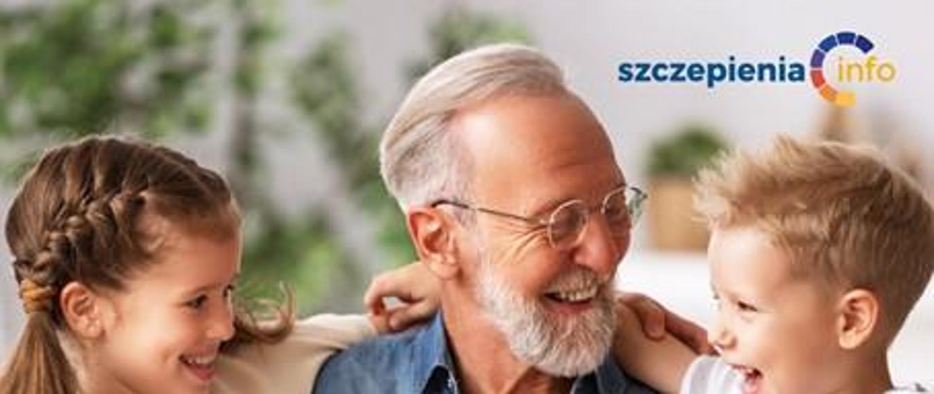 starszy mężczyzna uśmiechnięty trzyma na kolanach dwoje małych dzieci