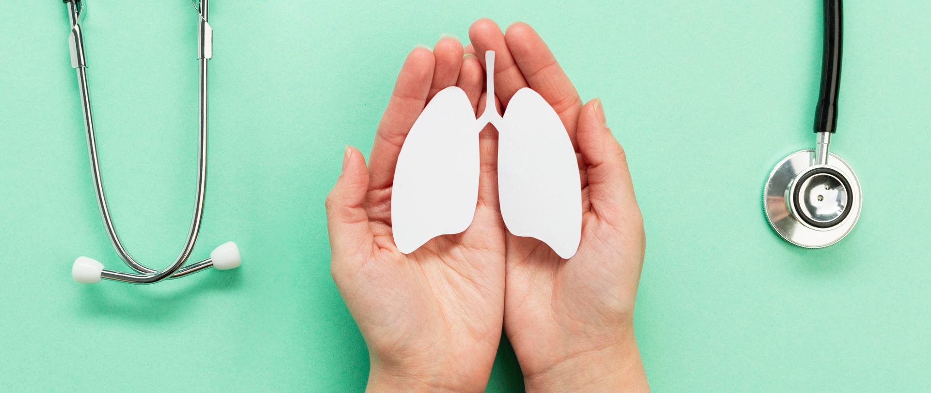 Zdjęcie przedstawia dłonie, w których znajdują się płuca, co symbolizuje troskę o ten narząd. Całość otacza stetoskop.