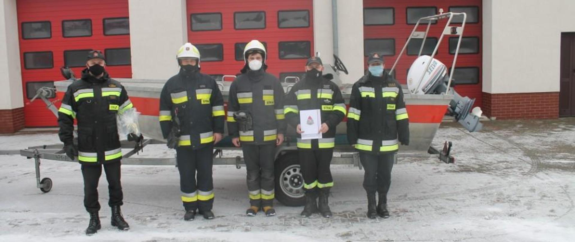 Zdjęcie przedstawia strażaków PSP i OSP wraz z przekazaną łodzią.