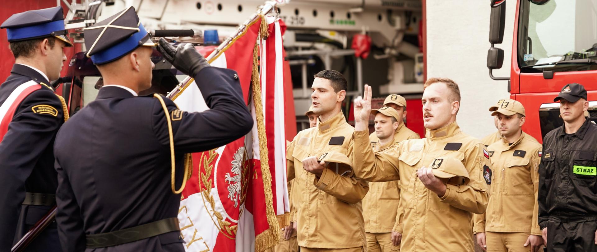 Nowo przyjęci strażacy wraz z kadrą kierowniczą KP PSP Ustrzyki Dolne podczas uroczystości ślubowania i jubileuszu 20-lecia służby st. kpt. Marcina Piękowskiego.