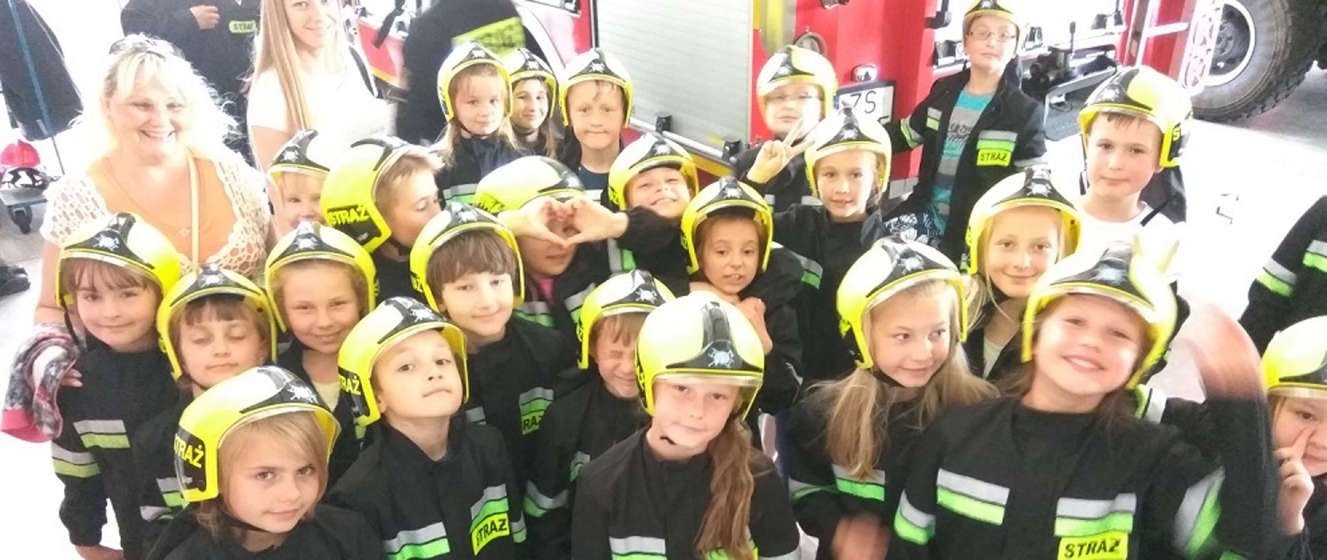 Zdjęcie przedstawia dzieci przy samochodzie gaśniczym