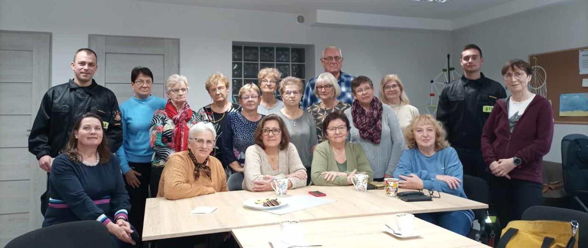 Na zdjęciu strażacy opowiadają seniorom