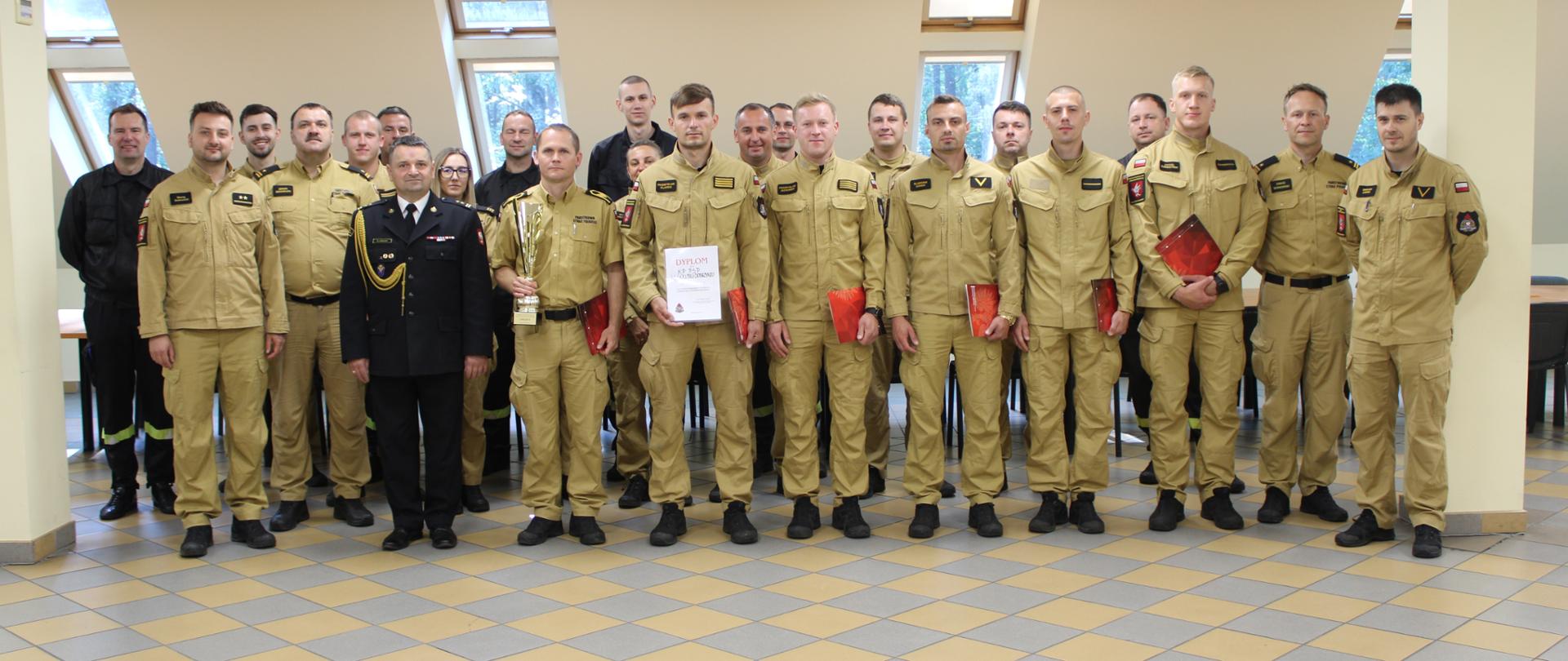 Uczestniczy uroczystej zbiórki stoją ustawieni w dwóch szeregach.