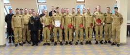 Uczestniczy uroczystej zbiórki stoją ustawieni w dwóch szeregach.