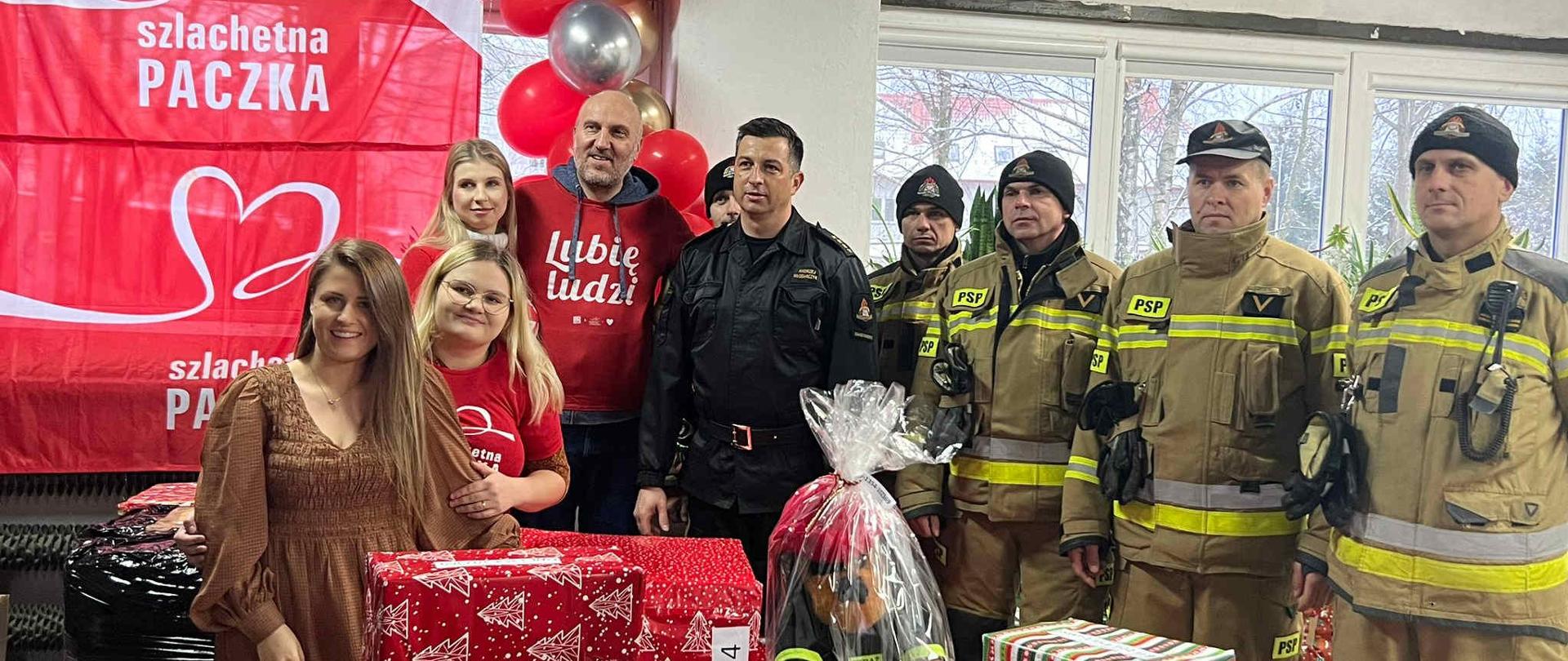 Na zdjęciu widać strażaków i przygotowane paczki. 