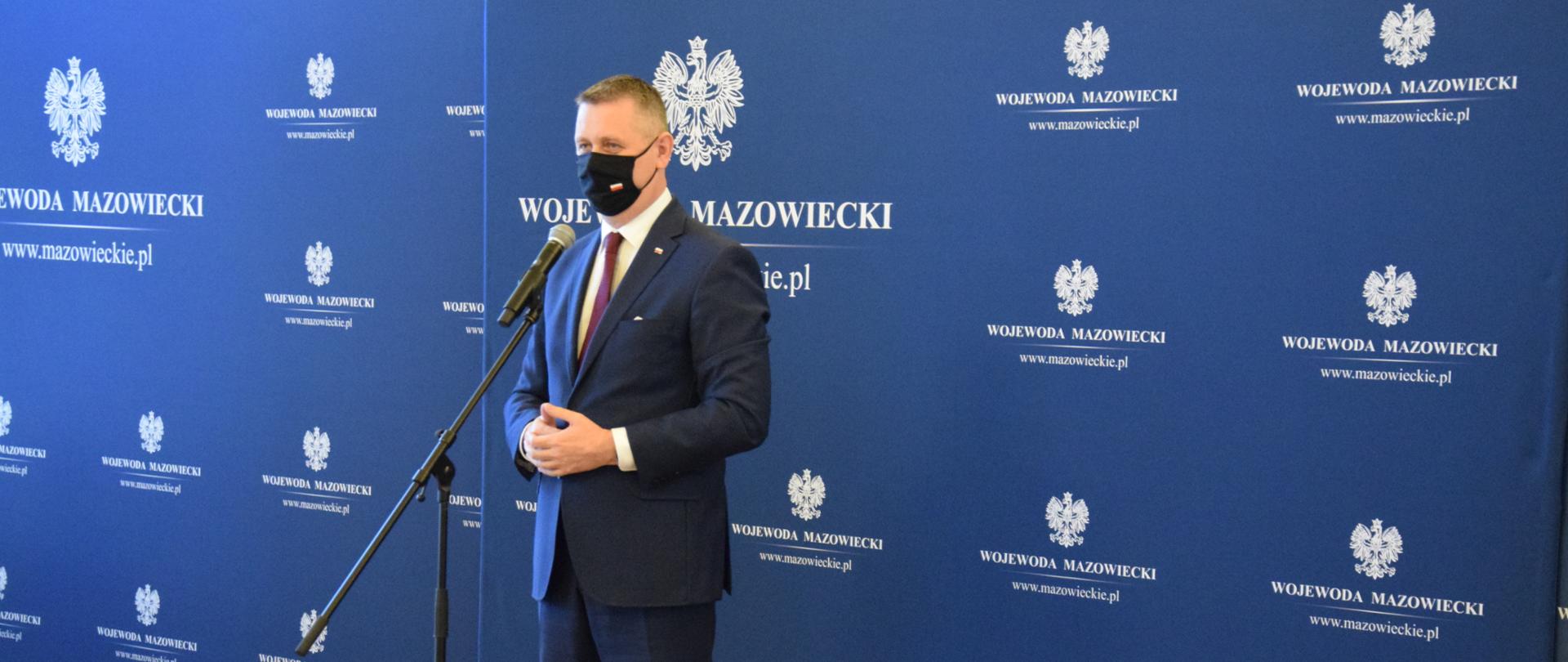 Na zdjęciu znajduje się mężczyzna mówiący do mikrofonu