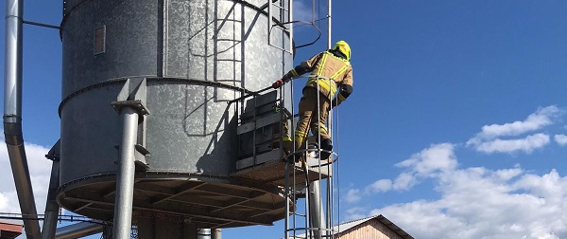 Zdjęcie przedstawia strażaków gaszących silos