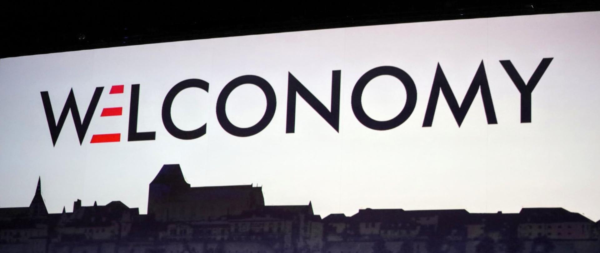 Logo Welconomy na tle nieba i cieni domów, z datą 14-15 września 2020