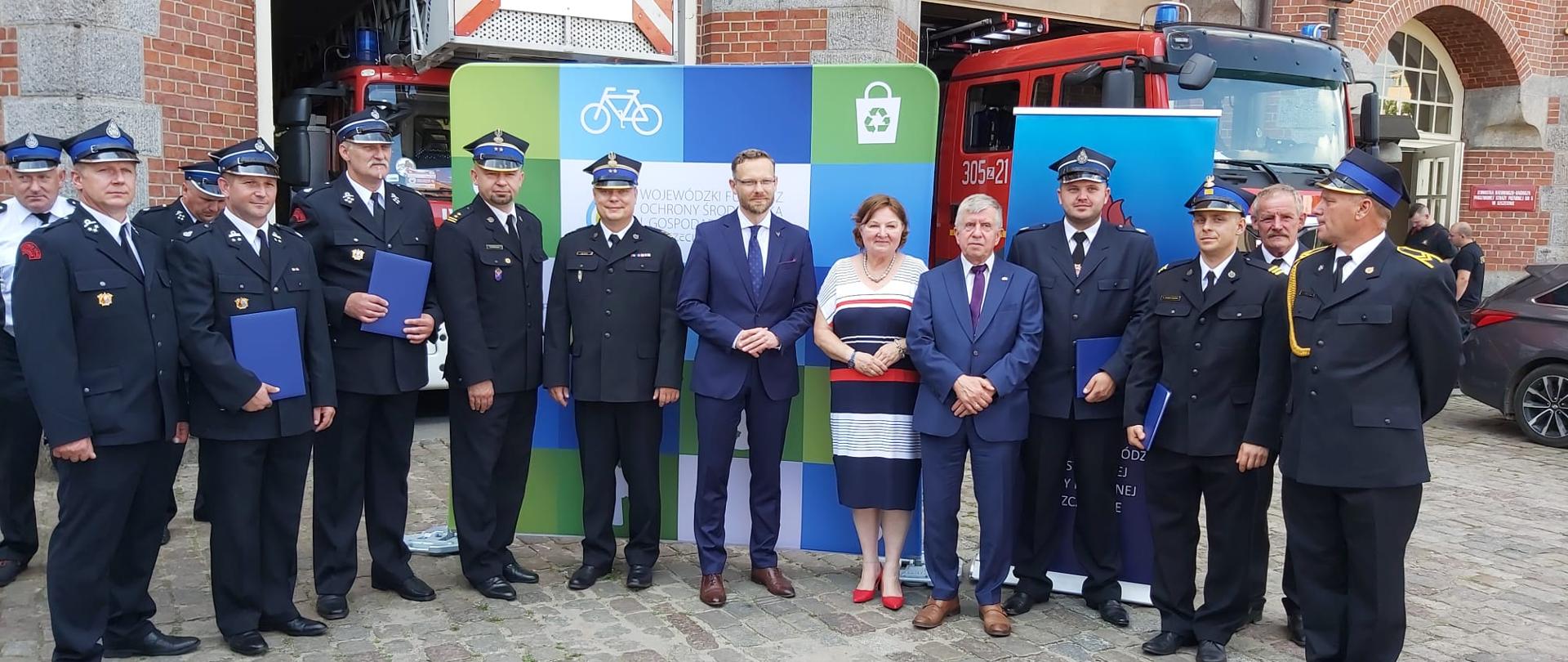 zdjęcie przedstawia strażaków oraz osoby uczestniczące w uroczystości ustawione w szeregu do zdjęcia.