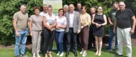 Grupa osób- rolników, stoi na łonie natury, w rzędzie do zdjęcia
